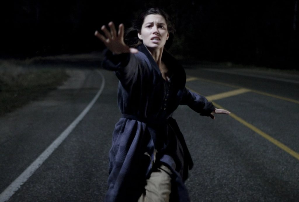 актриса Джессика Билл бежит по дороге протягивая руку