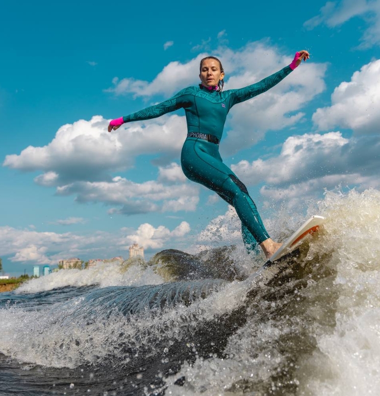 Екатерина Шугаева катается на серфинге, на доске по реке